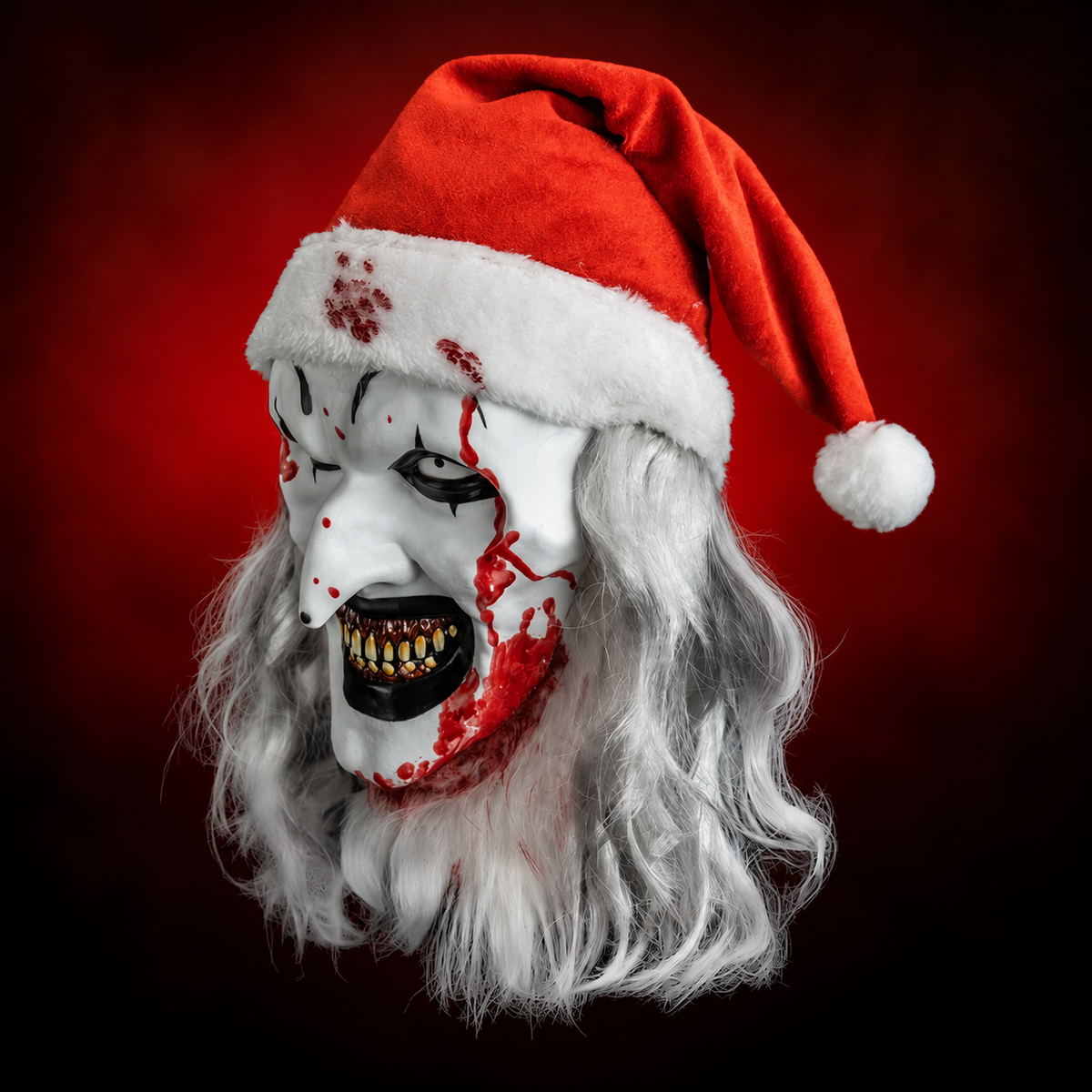 Santa Art the Clown Deluxe Injection Mask from Terrifier 3, left-facing angled view against red radiant background
