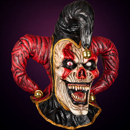 Evil Jester mask, view 1, against a smooth dark plum-charcoal gradient background