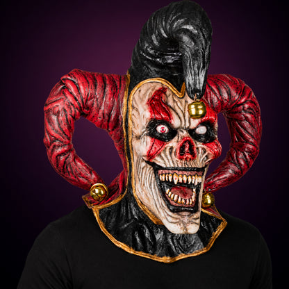 Evil Jester mask, view 3, against a smooth dark plum-charcoal gradient background
