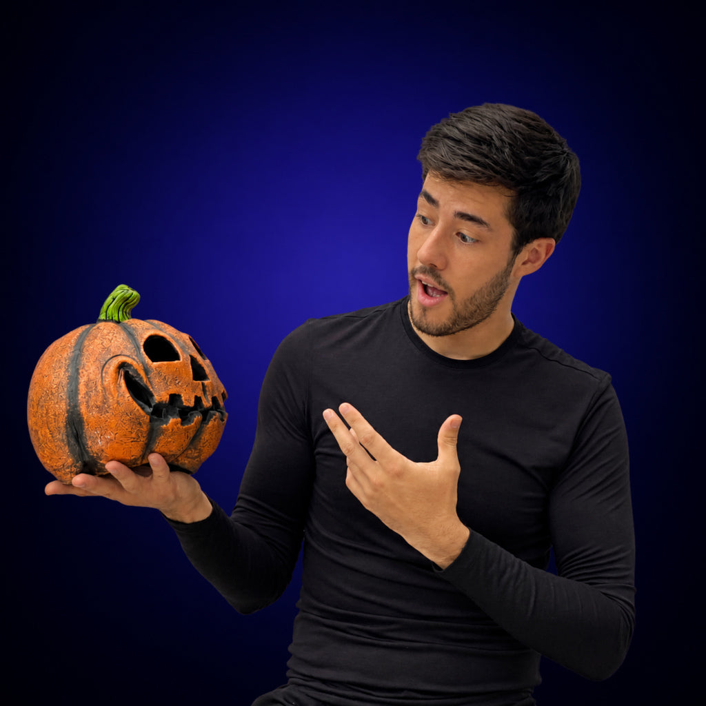 Funny Pumpkin decoration held by a model against a smooth dark indigo gradient background
