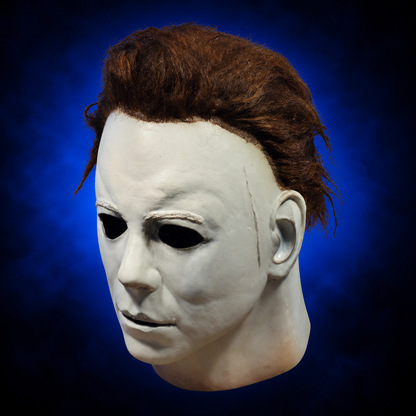 Halloween (1978) Michael Myers mask, left-facing angled view against dark blue radiant background